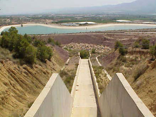 Foto vista del canal del aliviadero y al fondo la balsa de regulación